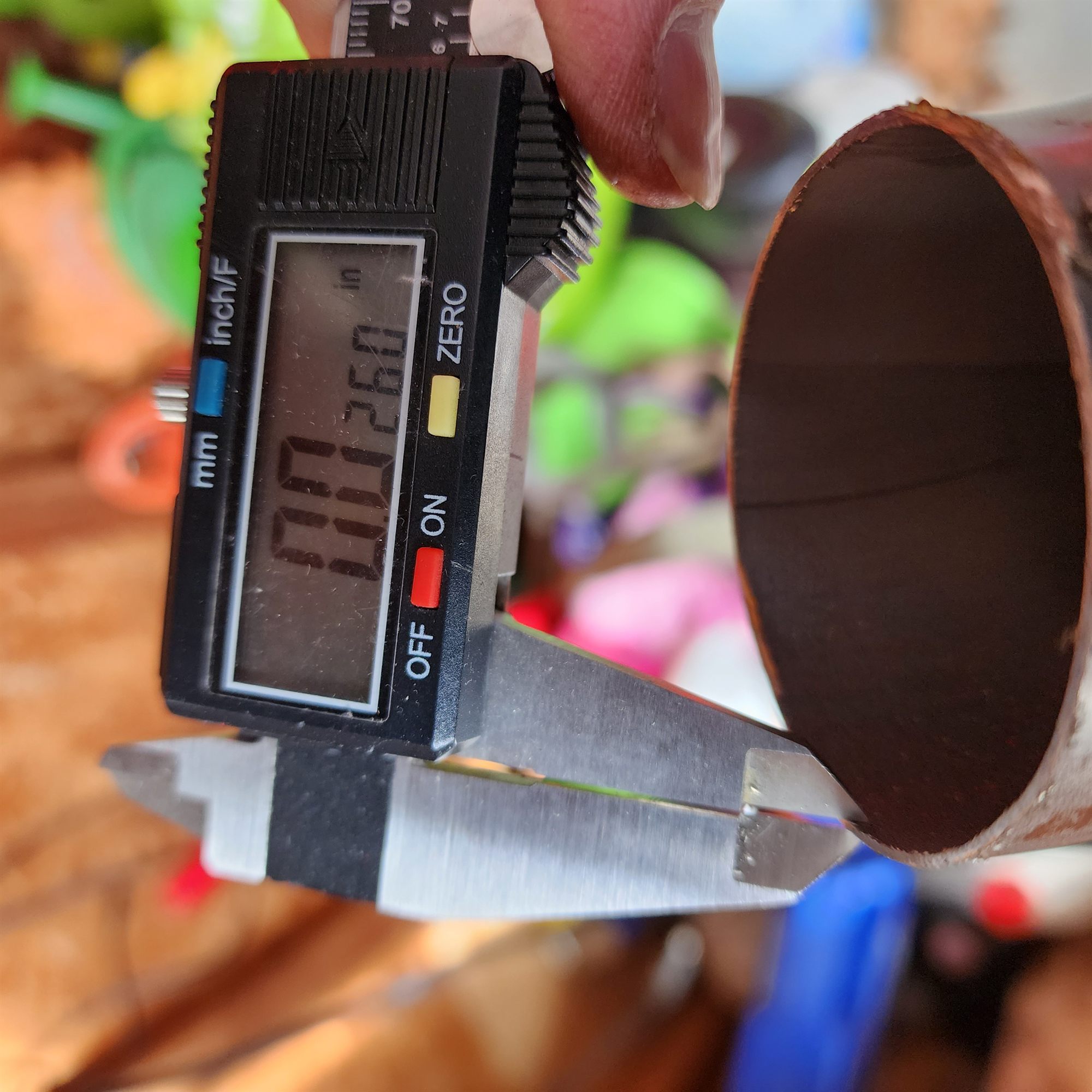 Caliper measuring tube wall thickness through a bend